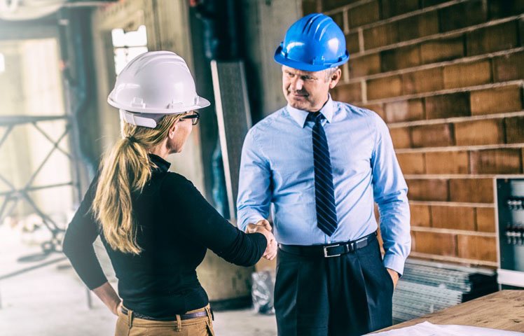 Two developers shaking hands while in a new development